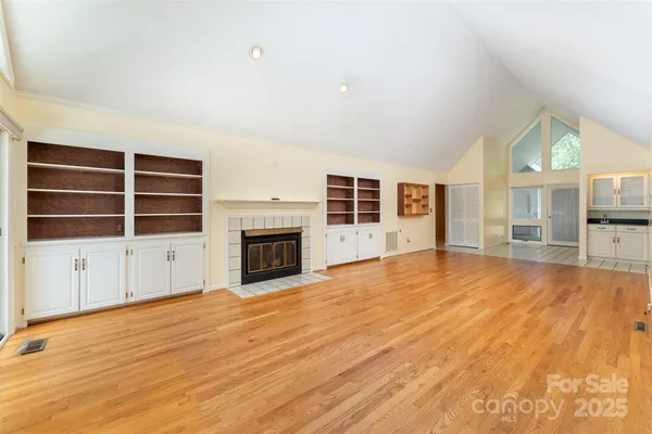 a view of an empty room with a fireplace and a window