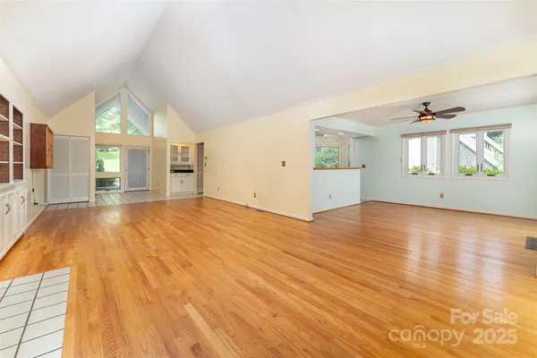 an empty room with wooden floor and windows
