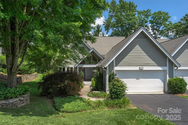a view of house with garden and tall trees