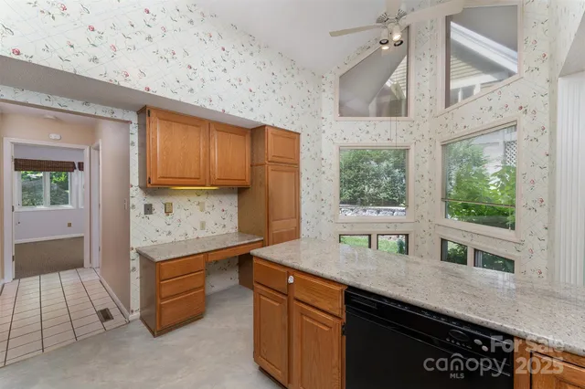 a kitchen with stainless steel appliances granite countertop a sink a stove and a wooden cabinets