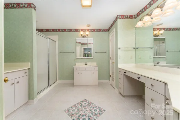 a spacious bathroom with a granite countertop sink and a mirror