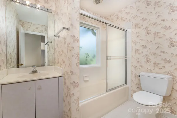 a bathroom with a granite countertop sink toilet a mirror and shower