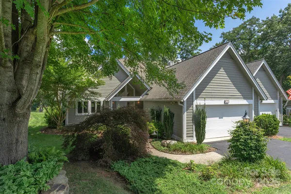 a view of a house with a yard and potted plants