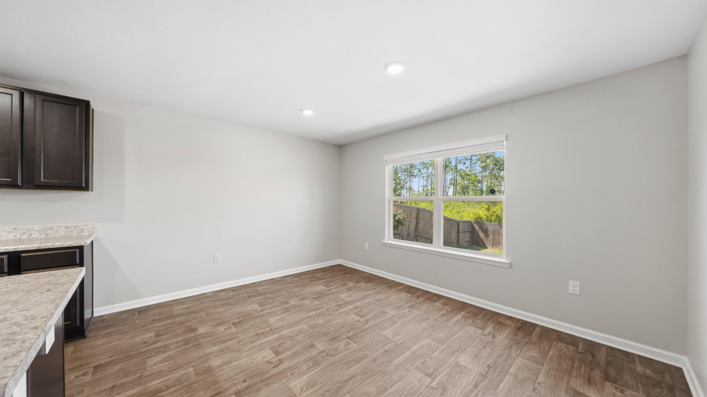 3927 Alva Thomas Road Panama City, FL 32404 - Photo 5 of 46 a view of an empty room with a window and wooden floor