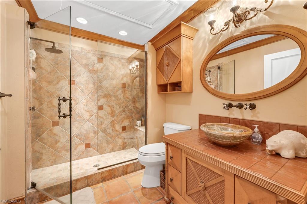 667 Bridge Way Lane Naples, FL 34108 - Photo 12 of 18 a bathroom with a granite countertop sink a toilet and a mirror