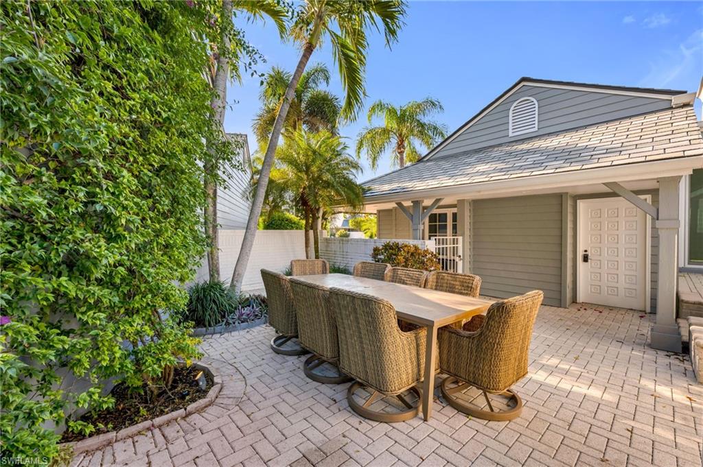 667 Bridge Way Lane Naples, FL 34108 - Photo 15 of 18 a view of a patio with table and chairs and potted plants