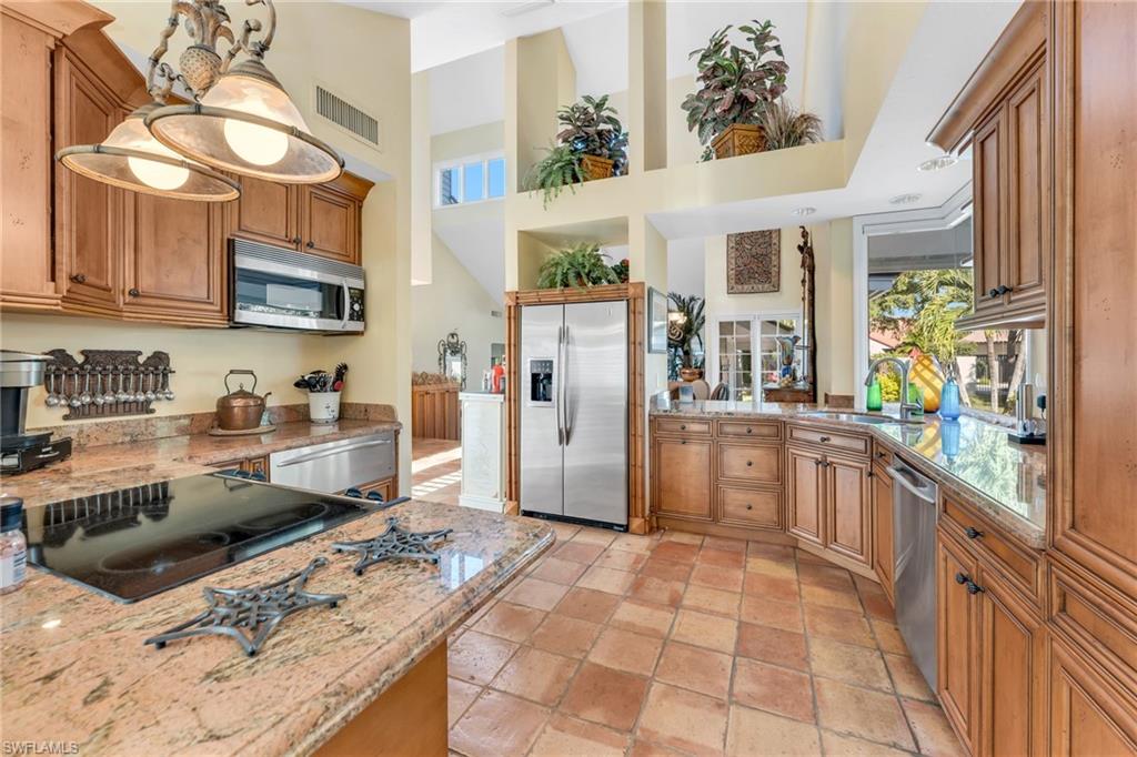 667 Bridge Way Lane Naples, FL 34108 - Photo 6 of 18 a kitchen with stainless steel appliances granite countertop a refrigerator and a stove