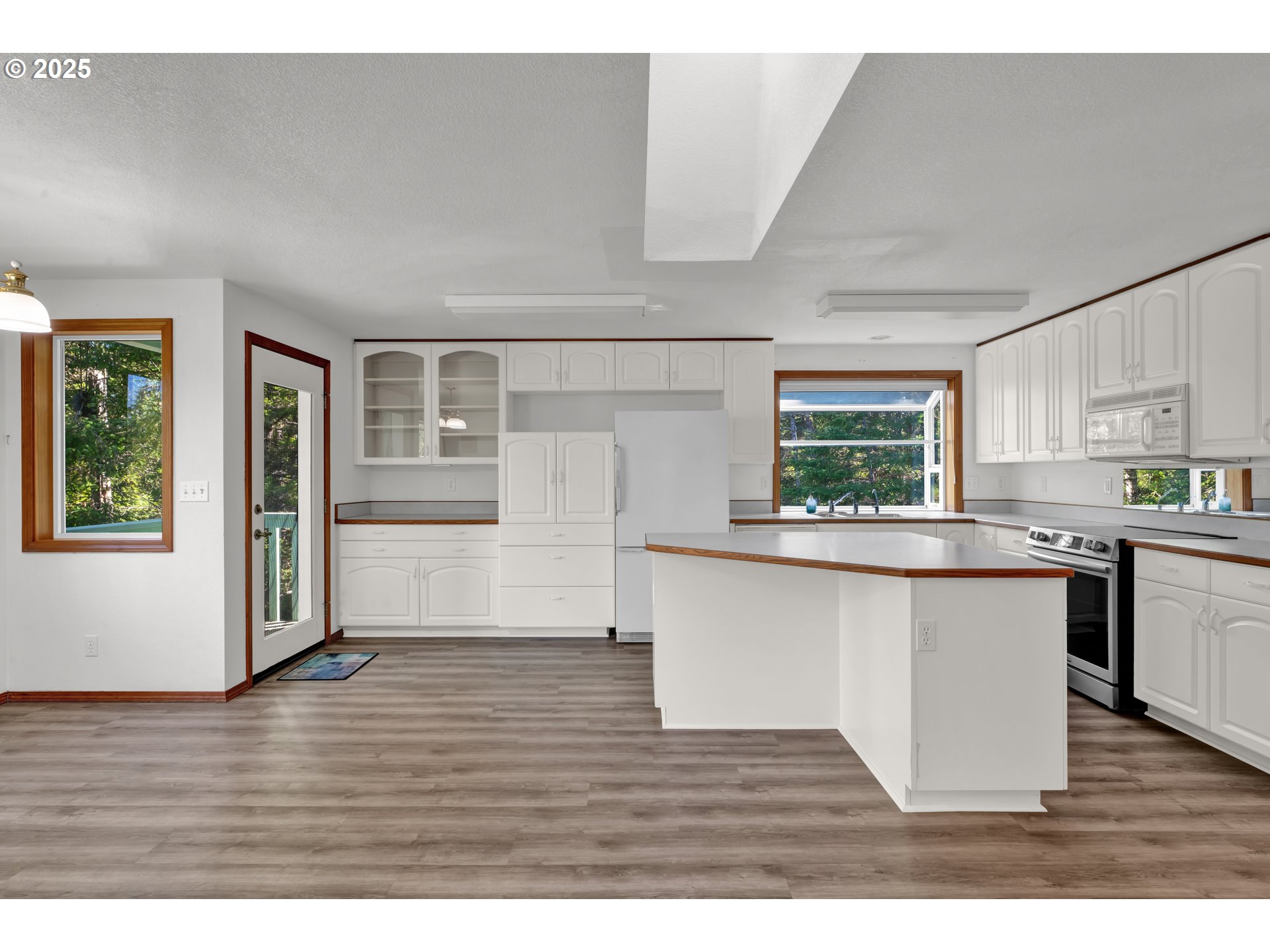 5603 Friendly Acres Road Florence, OR 97439 - Photo 5 of 45 a kitchen with stainless steel appliances granite countertop a refrigerator a sink dishwasher a stove and white countertops with wooden floor