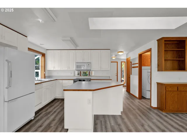 a kitchen with stainless steel appliances a sink and wooden cabinets