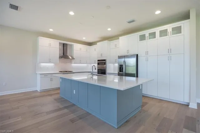 a kitchen with kitchen island sink stove and refrigerator
