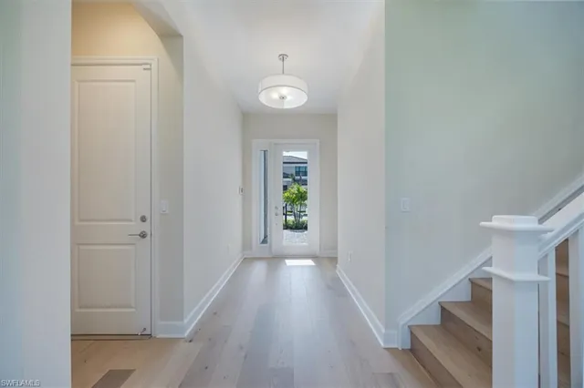a view of a hallway with wooden floor and staircase