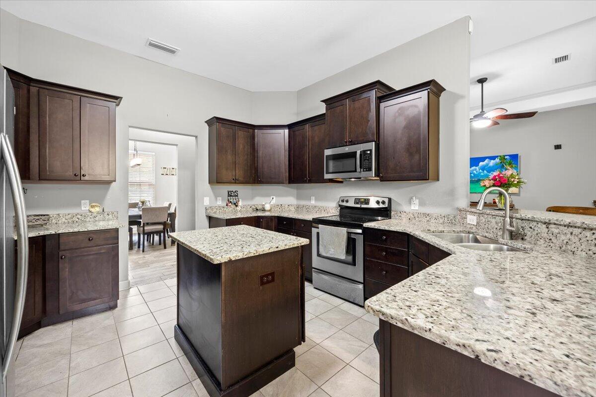 6057 Diamante Drive Crestview, FL 32539 - Photo 15 of 33 a kitchen with granite countertop stainless steel appliances and wooden cabinets