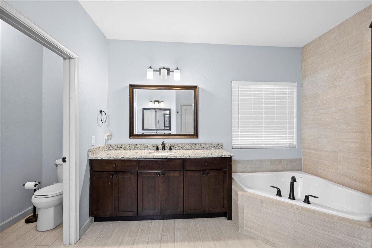 6057 Diamante Drive Crestview, FL 32539 - Photo 21 of 33 a bathroom with a granite countertop sink a toilet and bathtub