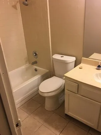 a white toilet sitting next to a bath tub