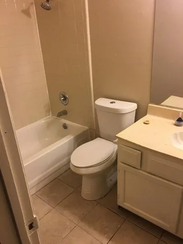 a white toilet sitting next to a bath tub