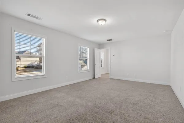 a bedroom with a bed flat screen tv and a window