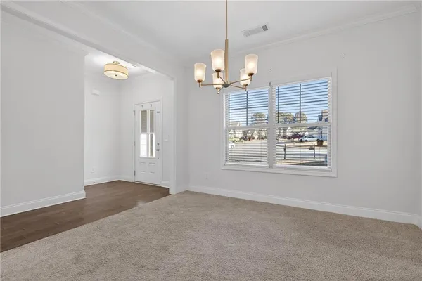 a view of a livingroom with a chandelier fan and windows