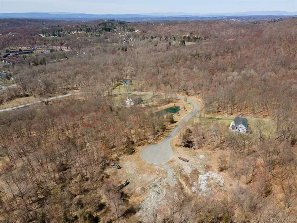 an aerial view of house with yard and mountain view in back