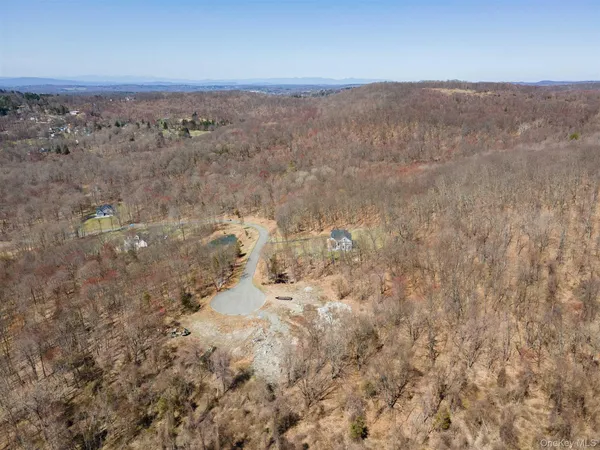 an aerial view of house with yard and mountain in the background