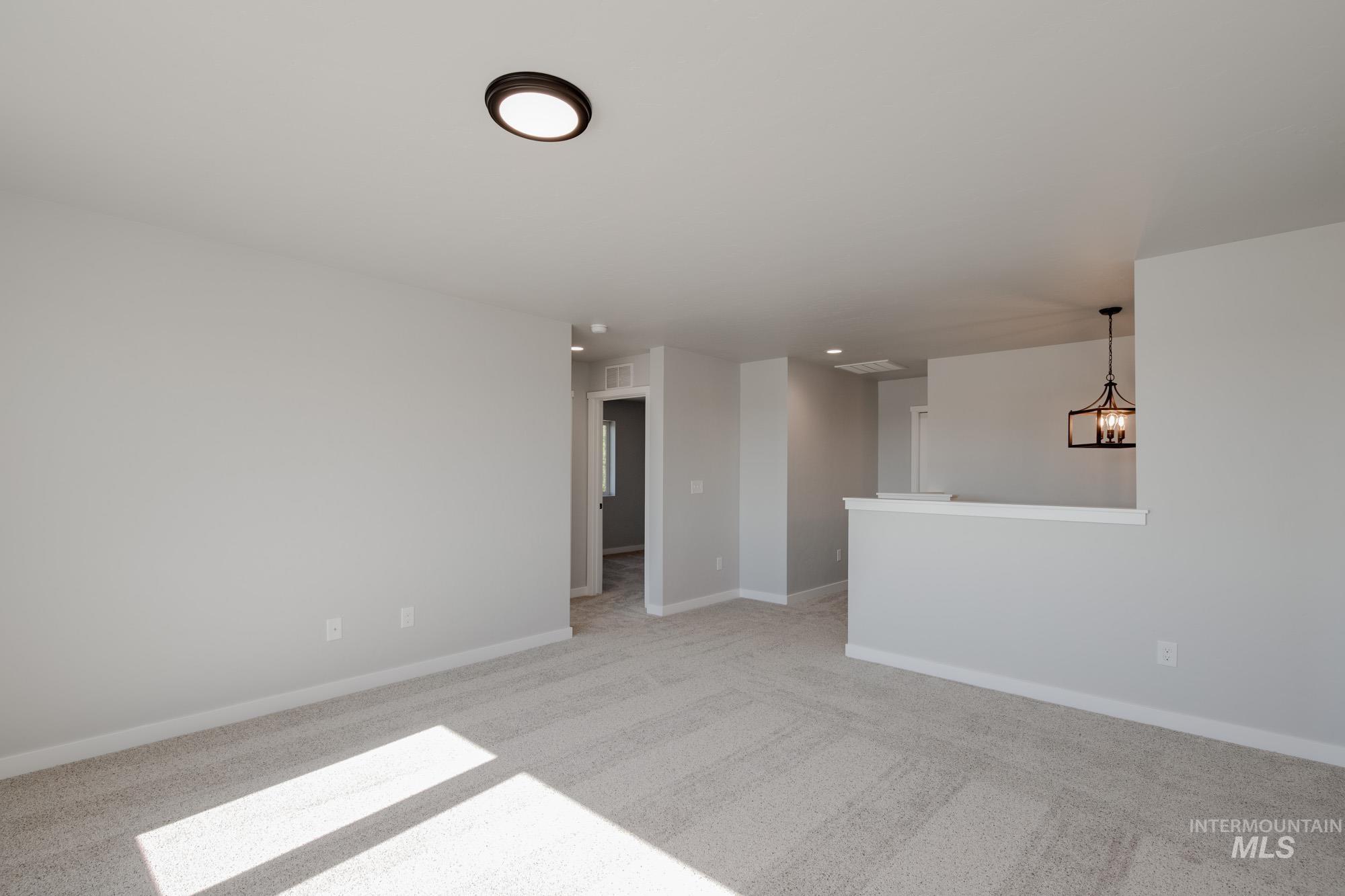 13727 Judson Street Caldwell, ID 83607 - Photo 20 of 26 Unfurnished room featuring a chandelier and light colored carpet