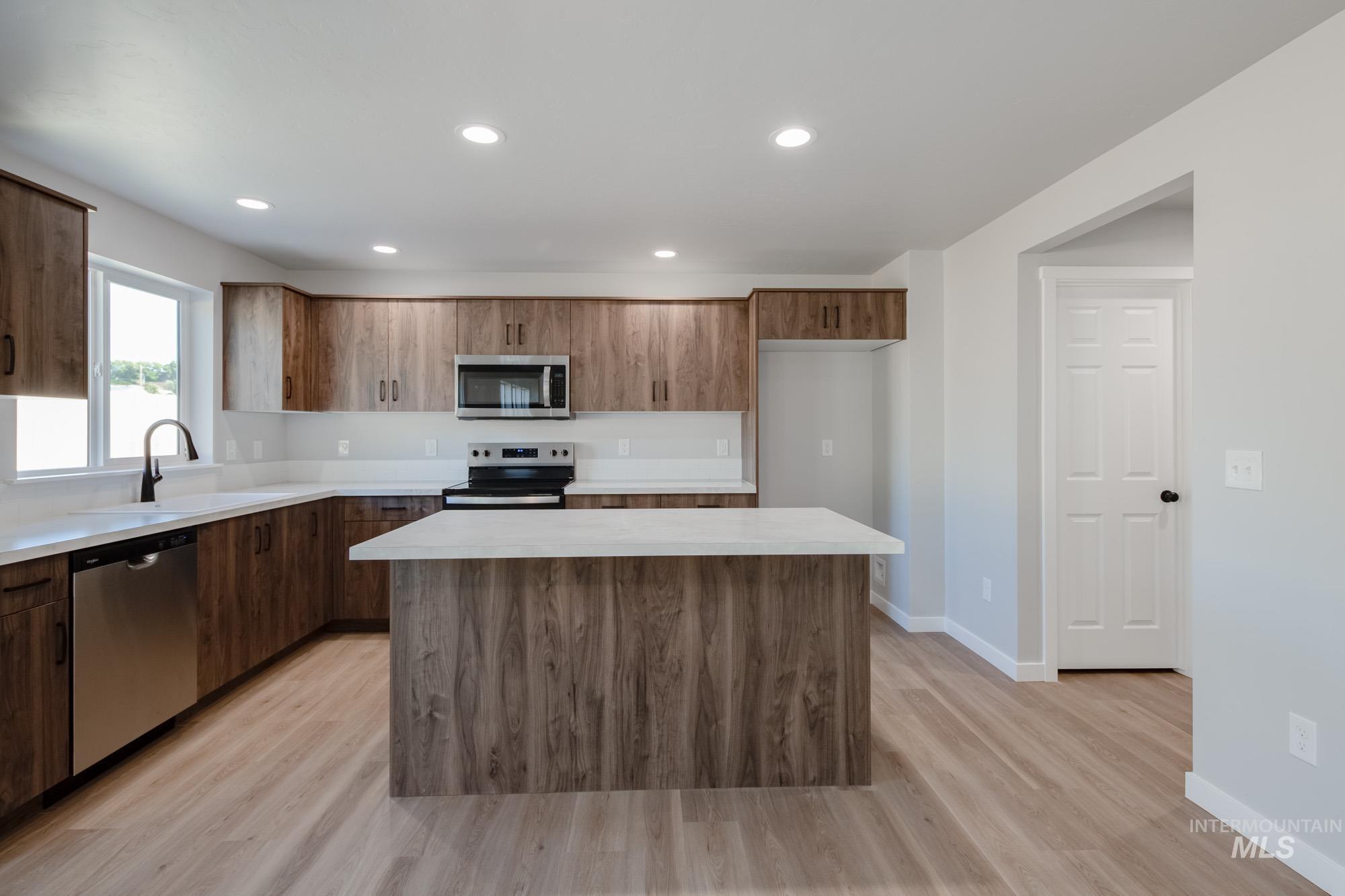 13727 Judson Street Caldwell, ID 83607 - Photo 4 of 26 Kitchen with stainless steel appliances, recessed lighting, a center island, light wood-style floors, and modern cabinets