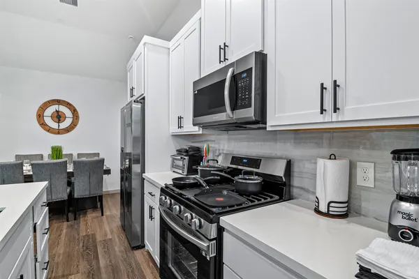 a kitchen with stainless steel appliances granite countertop a stove and a microwave