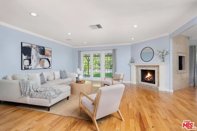 a living room with furniture a fireplace and a large window