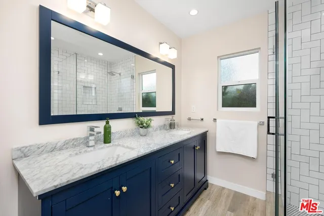 a bathroom with a granite countertop double vanity sink and a mirror