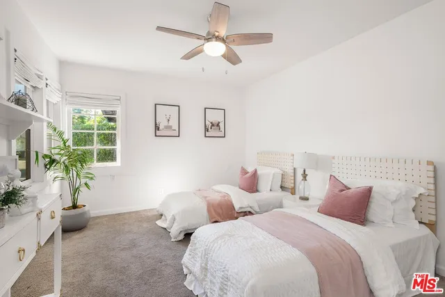 a bedroom with two beds and potted plant