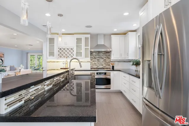 a kitchen with stainless steel appliances granite countertop a stove a sink and a refrigerator
