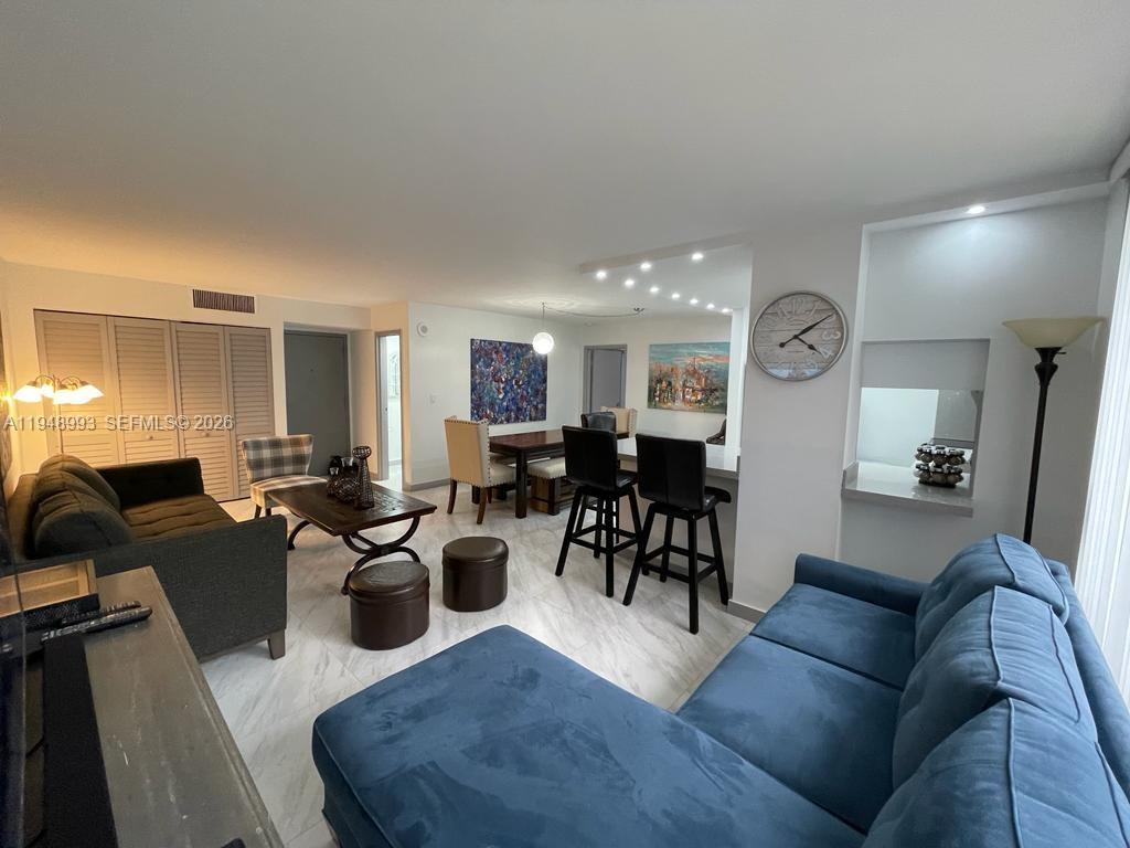a living room with lots of furniture and a view of kitchen