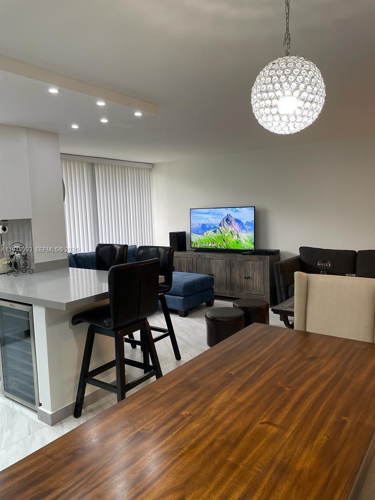 16919 North Bay Road, Unit 104 Sunny Isles Beach, FL 33160 - Photo 11 of 32 a view of a dining room with furniture and wooden floor