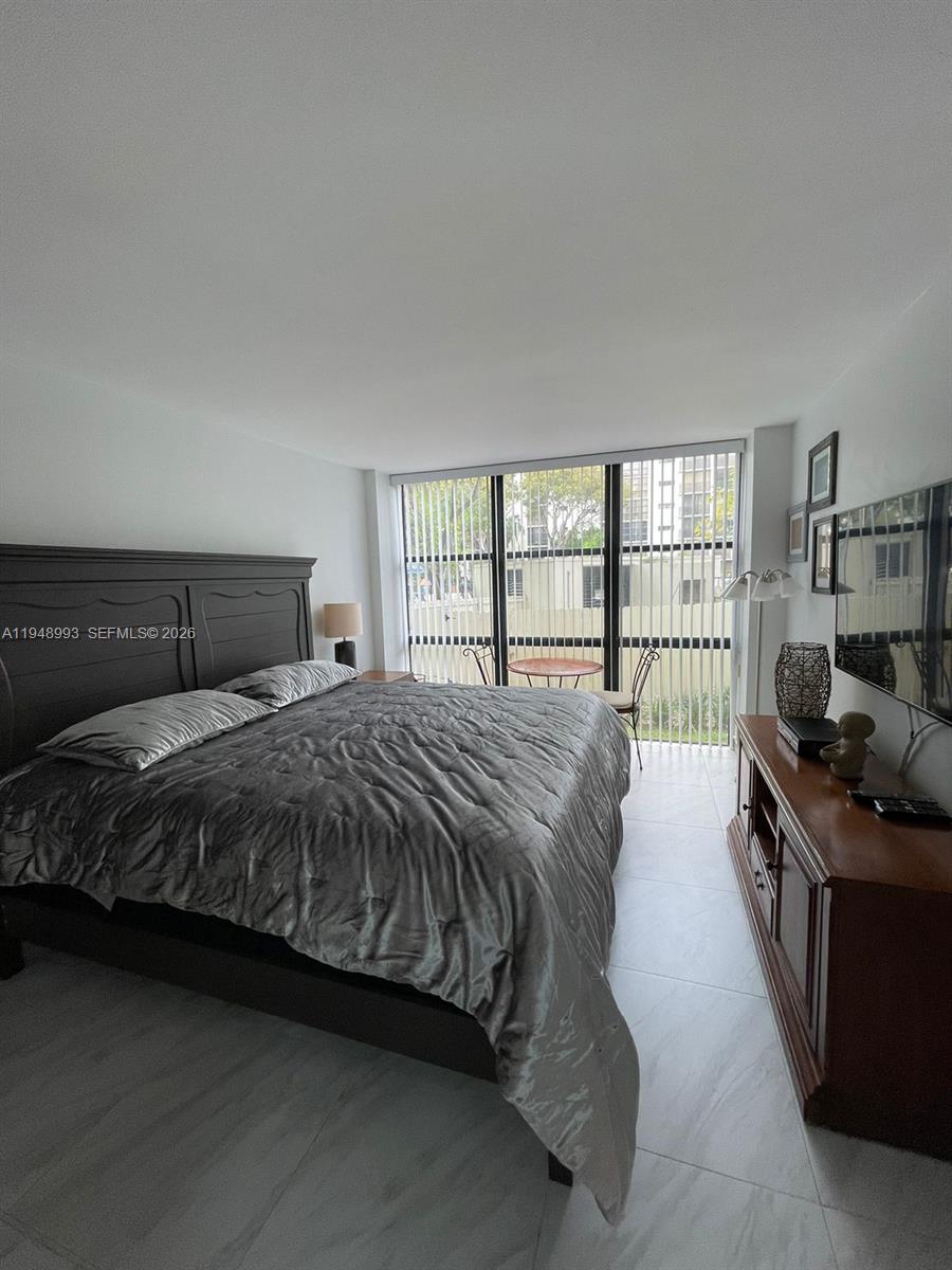 16919 North Bay Road, Unit 104 Sunny Isles Beach, FL 33160 - Photo 12 of 32 a bedroom with a bed and a window