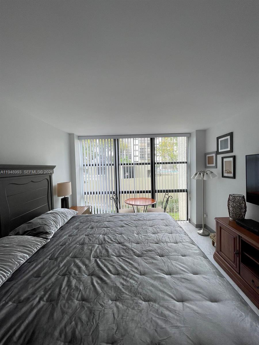 16919 North Bay Road, Unit 104 Sunny Isles Beach, FL 33160 - Photo 13 of 32 a bedroom with a large bed and a window