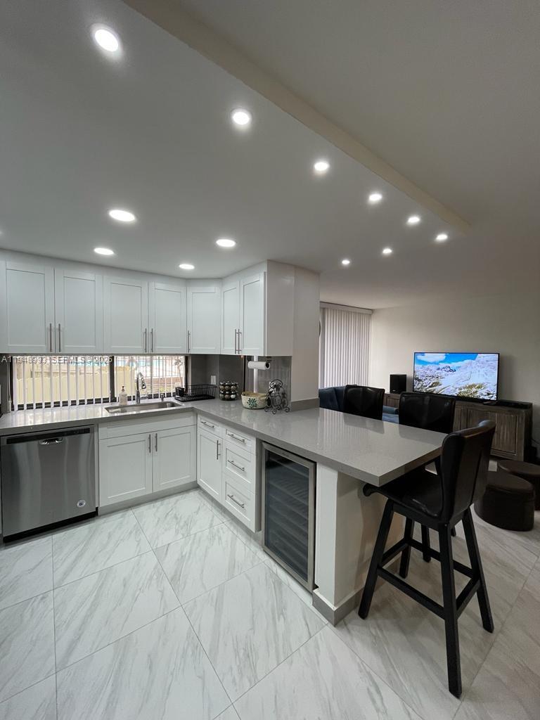 16919 North Bay Road, Unit 104 Sunny Isles Beach, FL 33160 - Photo 16 of 32 a kitchen with a table and chairs in it