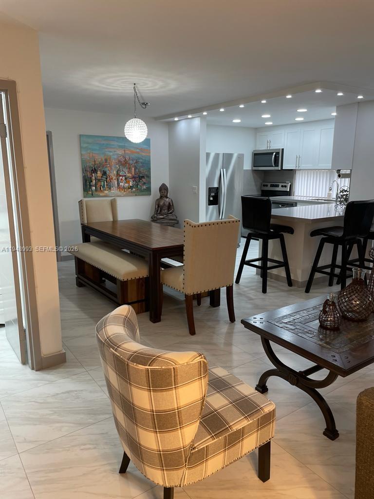 16919 North Bay Road, Unit 104 Sunny Isles Beach, FL 33160 - Photo 21 of 32 a living room with furniture and kitchen view