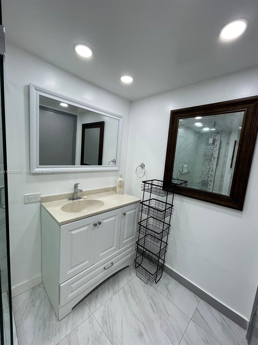 16919 North Bay Road, Unit 104 Sunny Isles Beach, FL 33160 - Photo 22 of 32 a bathroom with 2 sink and a mirror