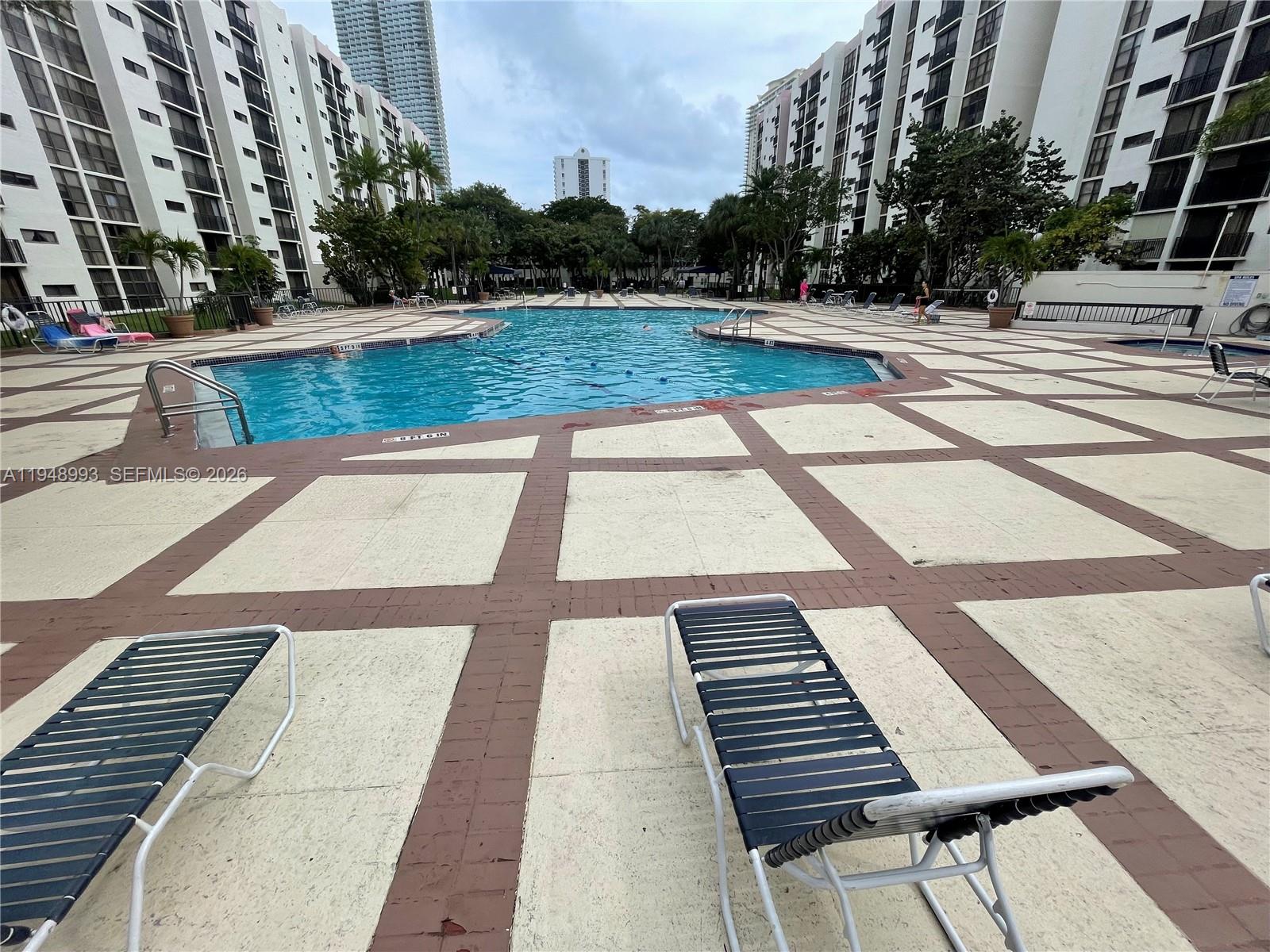 16919 North Bay Road, Unit 104 Sunny Isles Beach, FL 33160 - Photo 27 of 32 a view of swimming pool with outdoor seating and plants