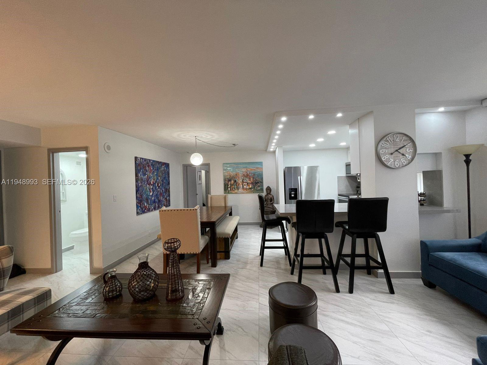 16919 North Bay Road, Unit 104 Sunny Isles Beach, FL 33160 - Photo 4 of 32 a living room with furniture and wooden floor
