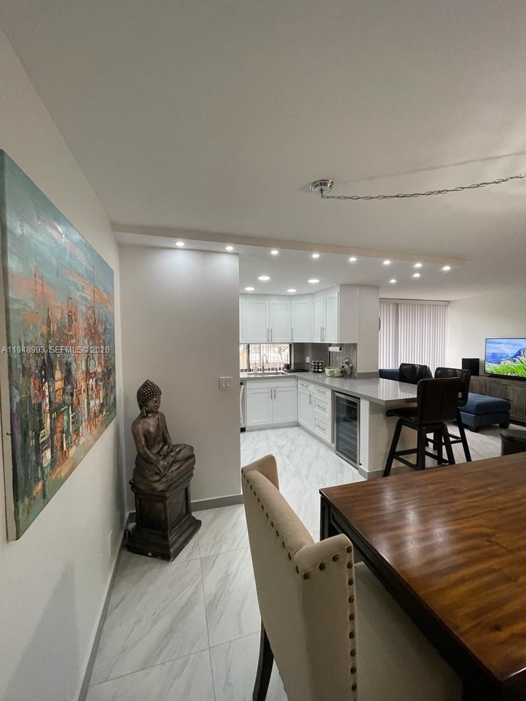 16919 North Bay Road, Unit 104 Sunny Isles Beach, FL 33160 - Photo 7 of 32 a kitchen with a table and chairs