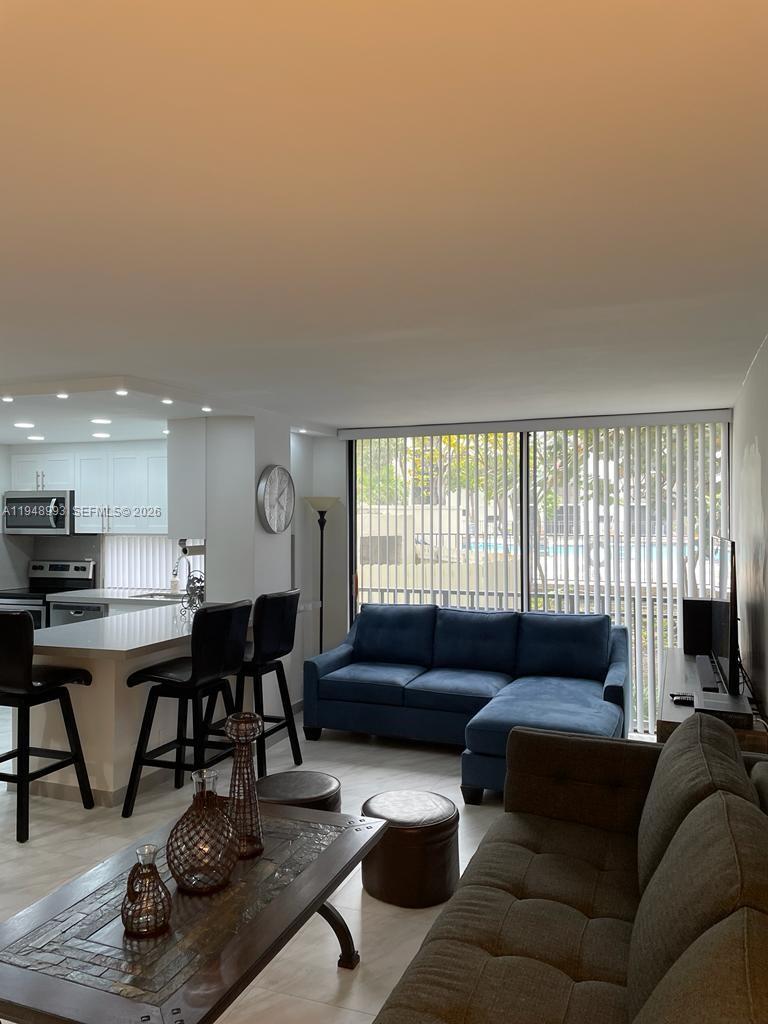 16919 North Bay Road, Unit 104 Sunny Isles Beach, FL 33160 - Photo 8 of 32 a living room with furniture a window and a fireplace