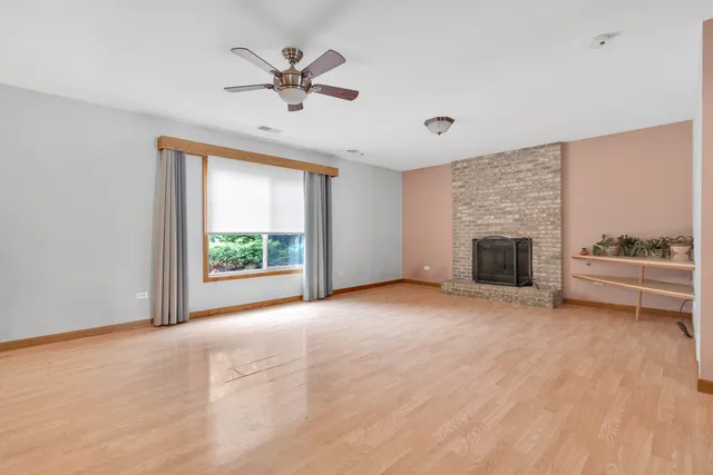 a view of an empty room with a window and a fireplace