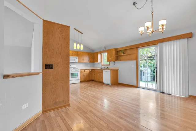 a view of a kitchen with a stove fridge and wooden floor