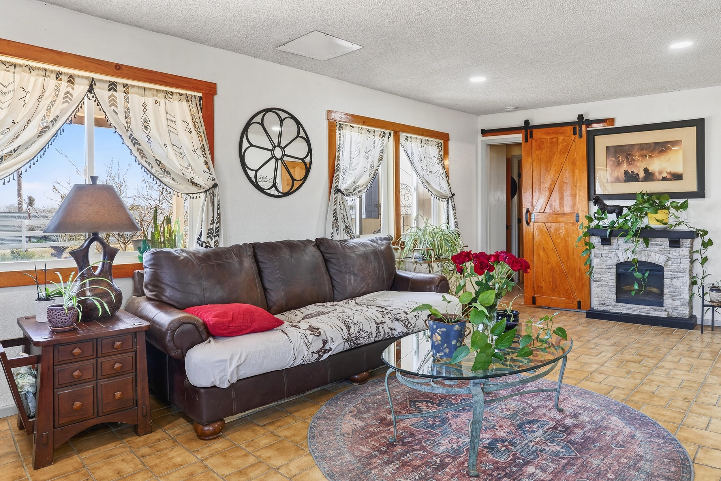 1588 Old Woman Springs Road Yucca Valley, CA 92284 - Photo 12 of 37 a living room with furniture a fireplace and a chandelier