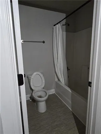 a view of a hallway with wooden floor and closet
