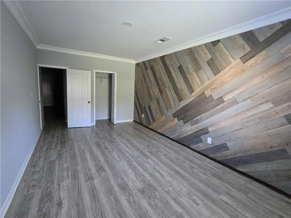an empty room with wooden floor a fireplace and windows