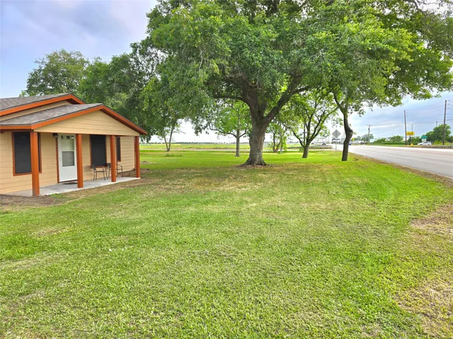 a view of a house with a yard and tree s