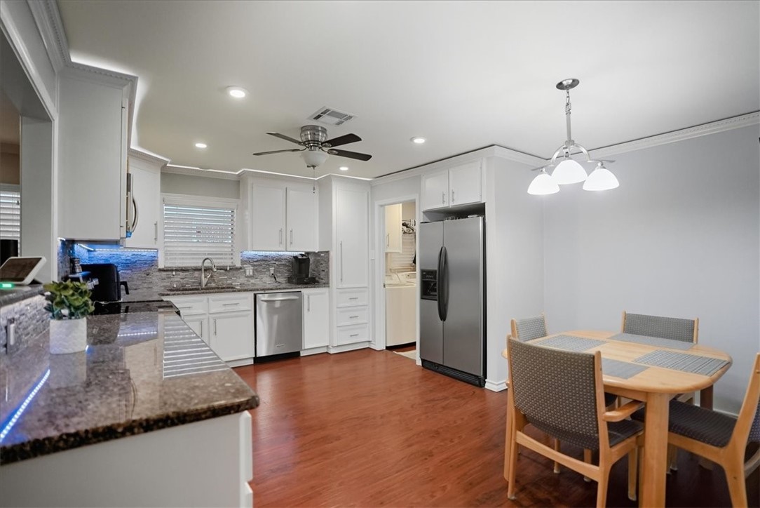 4218 Beard Drive Corpus Christi, TX 78413 - Photo 11 of 31 a kitchen with stainless steel appliances granite countertop a stove refrigerator and white cabinets with wooden floor