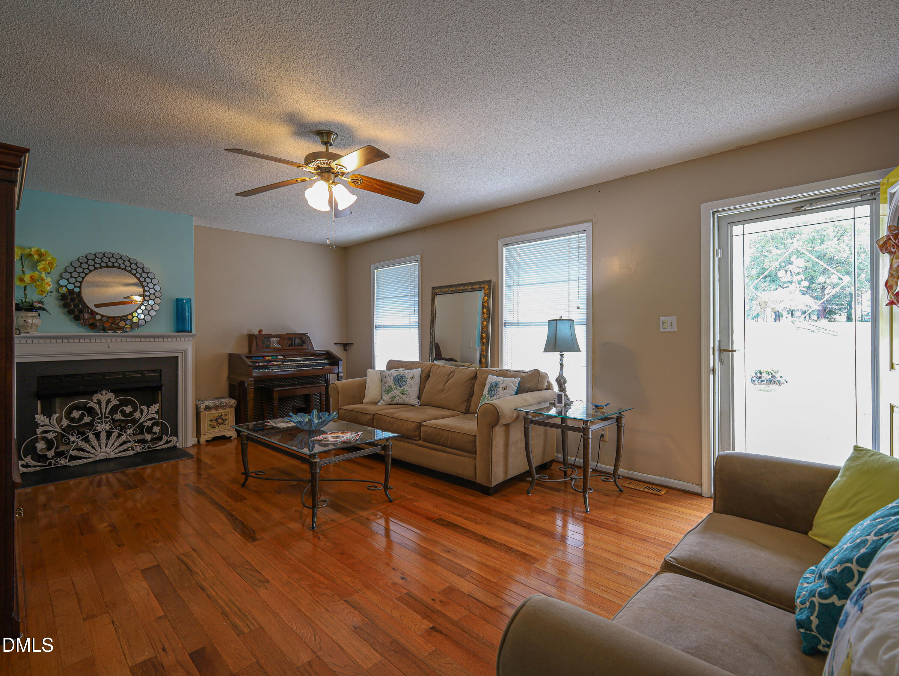 182 Scotts Lane Angier, NC 27501 - Photo 3 of 12 a living room with furniture a fireplace and a ceiling fan