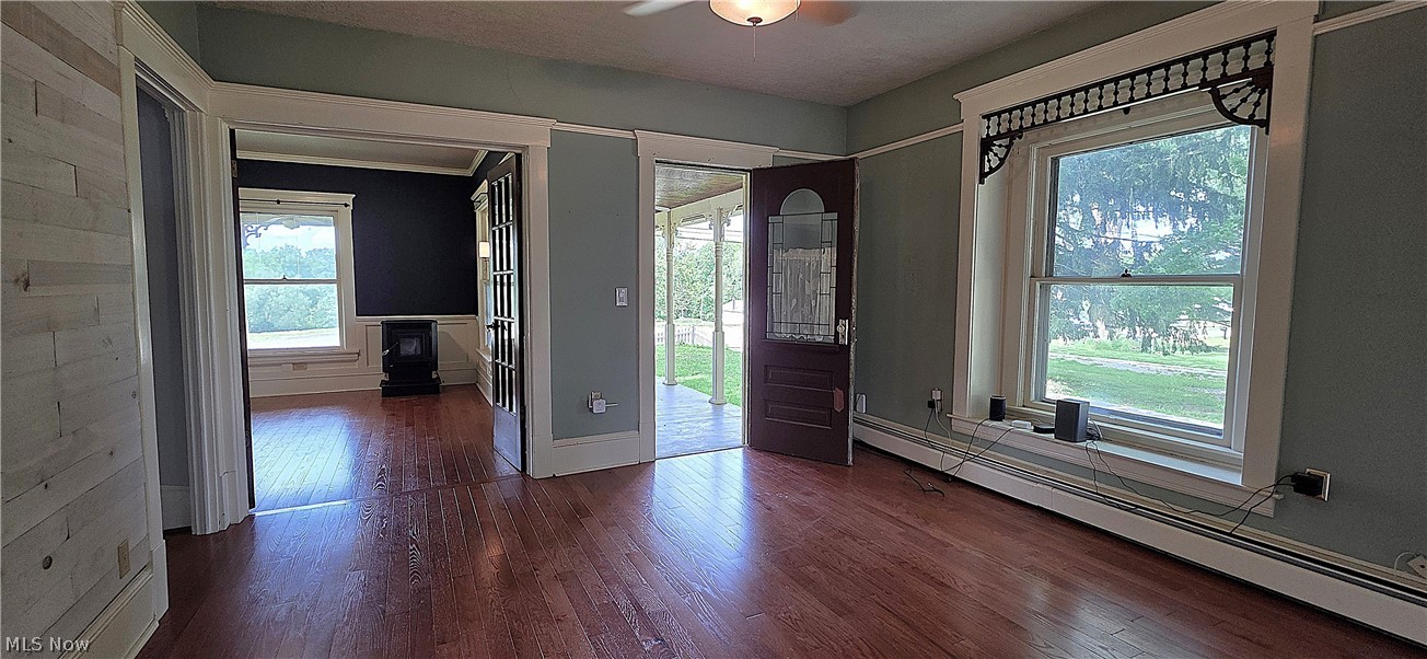 7414 Greenwich Road Seville, OH 44273 - Photo 16 of 50 Living room featuring beautiful woodwork, hardwood floors, and a charming built-in window seat overlooking the porch. Open to the wrap around porch